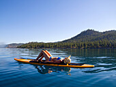 Woman Laying Down on Paddleboard on Lake 4