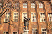 Sculpture of Violinist in Front of Brick Building