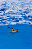 Female Kayaker Enjoying The Surreal Enviroment Of A Meltpond On The Juneau Ice Field. Summer In Southeast Alaska.