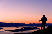 Male Hiker Standing On Ridge Overlooking Lynn Canal & Berner's Bay Near Juneau Alaska At Sunset