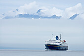 The Alaska Marine Highway M/V Malaspina Travels In Lynn Canal With Lions Head Peeking Through Fog In The Background