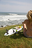 USA, Rhode Island, Newport, Young woman in bikini having picnic on surfboard, Judith Point