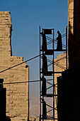 Silhouette of men putting up scaffolding on Karnak Temple, Precinct of Amun, Luxor, Egypt