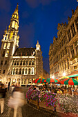 People eating and drinking at cafe tables at dusk in Grand Place, Brussels, Belgium