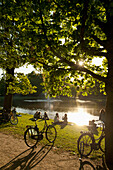 Couple relaxing by lakeside in Vondelpark, Amsterdam, Holland