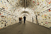 Pedestrians in a tunnel with walls covered in newspaper, Lugano, Ticino, Switzerland