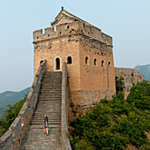 A tourist walking up the steps on the Great Wall of China, Beijing, China
