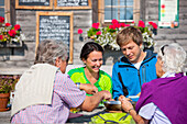 Four hikers having a snack in front of an alpine hut, Styria, Austria