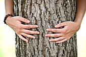 Woman hugging a tree, Styria, Austria