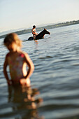 Woman riding a horse in lake Starnberg, girl in foreground, Ammerland, Munsing, Upper Bavaria, Germany