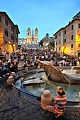 In the evening at the Bernini fountain on the Piazza de Spagna and the Spanish steps, Rome, Italy