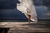 Braut steht auf einem Bootssteg vor Gewitterwolken, Starnberger See, Oberbayern, Bayern, Deutschland