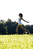 Young woman running over a meadow, Upper Bavaria, Bavaria, Germany