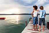 Zwei Jungen auf einem Bootssteg am Starnberger See, Oberbayern, Bayern, Deutschland