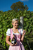 Wine princess Christina Schuhmann in front of the vineyard of Weingut Dahms winery, Sennfeld, near Schweinfurt, Franconia, Bavaria, Germany