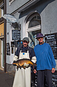 Main river fisherman Frank Dittmar with live carp and his father Gerhard Dittmar from Flussfischerei Dittmar fish shop, Schweinfurt, Franconia, Bavaria, Germany