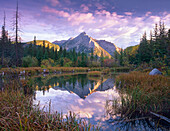 Mount Lorette and spruce trees reflected in lake, Alberta, Canada