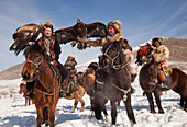 Golden Eagle (Aquila chrysaetos) group used for hunting, with their Kazak handlers competing at winter festival, Mongolia