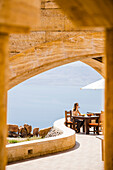 Frau sitzt beim Essen auf einer Terasse, Totes Meer und israelische Küste im Hintergrund, Jordanien, Naher Osten