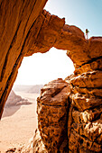 Frau steht auf Felsbrücke über den Jabal Burdah, Wadi Rum, Jordanien, Naher Osten