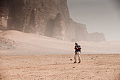 Woman hiking through desert scenery, Wadi Rum, Jordan, Middle East