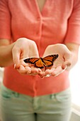 Girl holding a butterfly in her hands