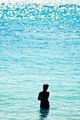 Silhouette of a woman standing in the sea.