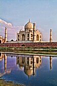 World famous Taj Mahal temple burial site at sunset from Yamuna River with reflection in town of Agra India