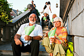 Couple sitting on staircase while eating French fries, Liege, Wallonia, Belgium