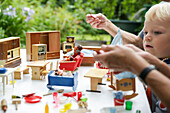 Boy playing with a doll's house, Freital, Saxony, Germany