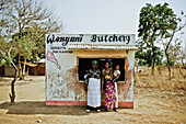 Mother, daughter and granddaughter in front of their family-owned butchers, outside of Lilongwe, Malawi, Africa