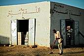 Man sweeping the street in front of his shop, Wadi Halfa, Sudan, Africa
