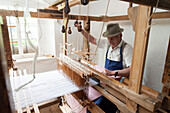 Weber arbeitet an Webstuhl, Webereimuseum Breitenberg, altes Bauernhaus, Bayerischer Wald, Bayern, Deutschland