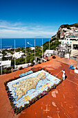 Frau reinigt eine gekachelte Karte der Insel Capri, Capri, Kampanien, Italien