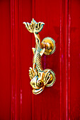 Golden door handle on a red door, Mdina, Malta