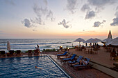 Pool direkt am Meer kurz nach Sonnenuntergang und Besucher am Pool des Galle Face Hotel, Colombo, Sri Lanka