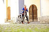 Young woman walking an electric bicycle, Tanna, Thuringia, Germany