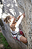 Frau klettert eine Felswand hinauf, Finale Ligure, Province of Savona, Liguria, Italy