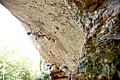 Mann klettert an einer Felswand, Finale Ligure, Provinz Savona, Ligurien, Italien