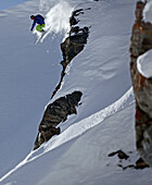 Freeskier springt über eine Felsklippe, Chandolin, Kanton Wallis, Schweiz