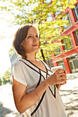 Woman holding a coffee to go, Munich, Bavaria, Germany