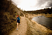 A woman jogging on a dirt trail in Oregon Terrebone, Oregon, USA