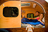 A young couple with their dog camping in a trailer near Big Sur Big Sur, California, USA