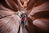 A couple hiking through a slot canyon in Utah Utah, USA
