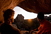 Two hikers enjoying a sunset from a rocky cliff at Vedauwoo, Wyoming Laramie, Wyoming, USA