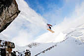 A male skier jumps off a cliff while skiing in the Wyoming back country Wyoming, USA