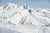 A group of backcountry skiers ski a wide open, alpine run in the Selkirk Mountains, Canada British Columbia, Canada