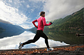 A female jogging along the Lake Crescent shore Port Angeles, Washington, USA