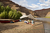 Two young girls playing near their mothers while camping on the San Juan River, Mexican Hat, Utah Mexican Hat, Utah, USA