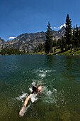A young man swims in a lake in Grand Teton National Park Jackson, Wyoming, USA